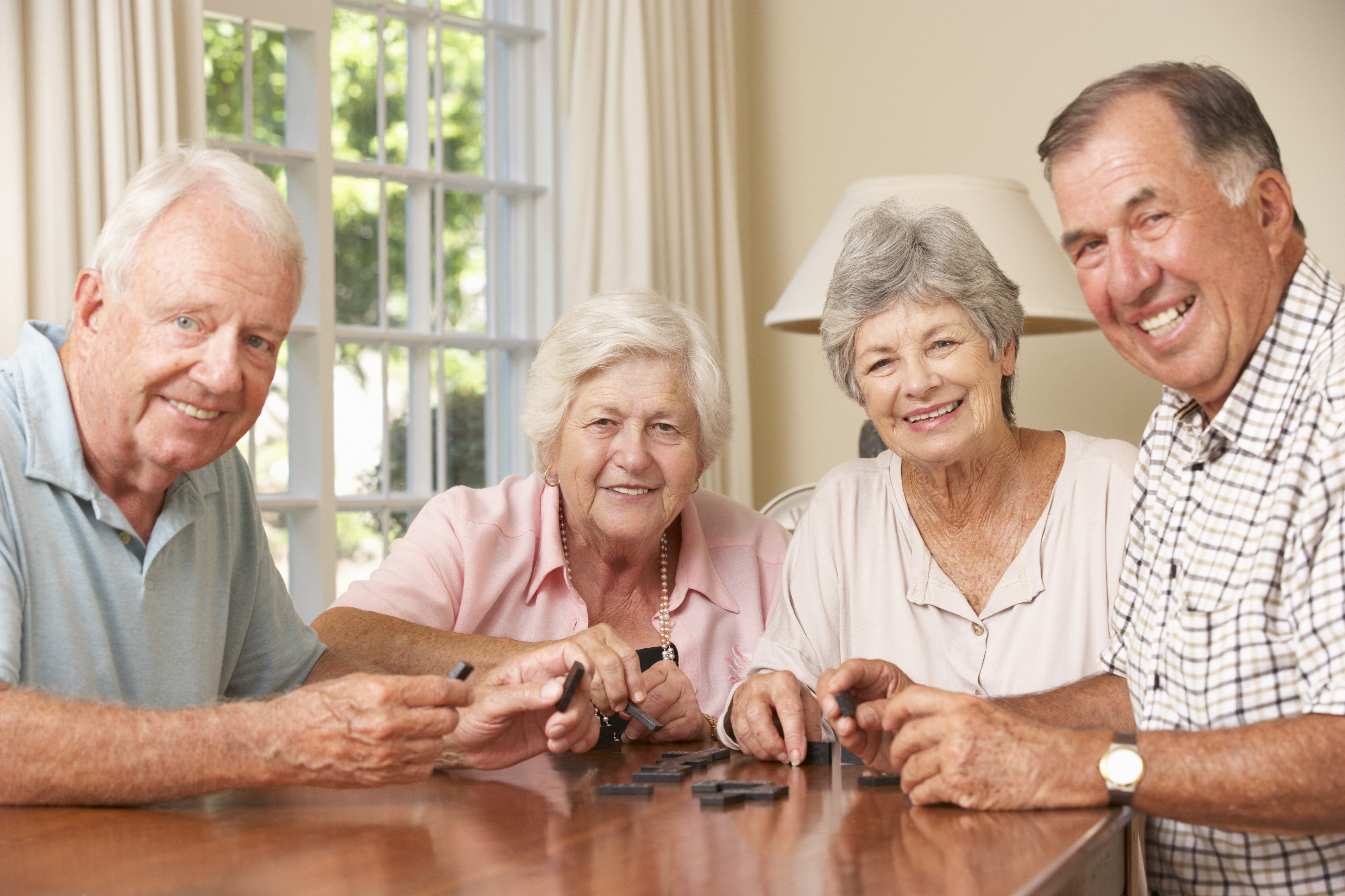 vier Senioren spielen Domino