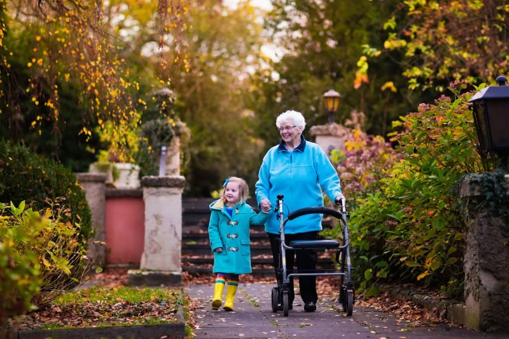 Oma mit Rollator und Enkelin gehen spazieren