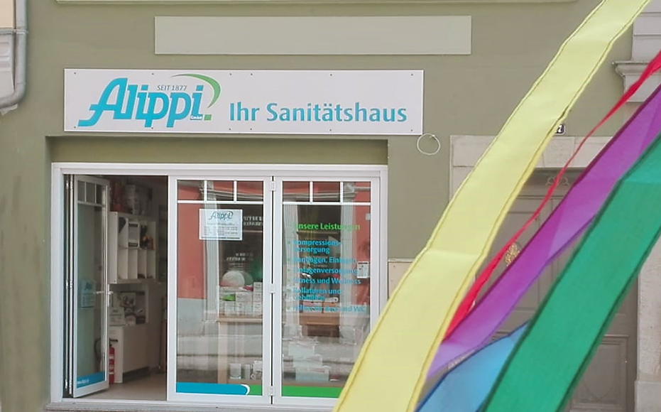 Außenansicht Sanitätshausfiliale in Eisenberg, Schild über Tür Sanitätshaus Alippi